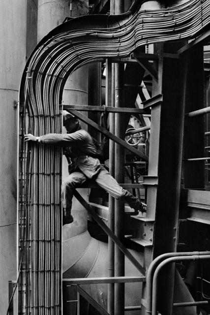 SEBASTIÃO SALGADO. Worker repairs pipes that are part of the electronic wiring system around the blast furnace number 4. Dunkerque. France, 1987